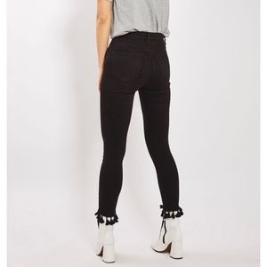 Black jeans with tasseled hem